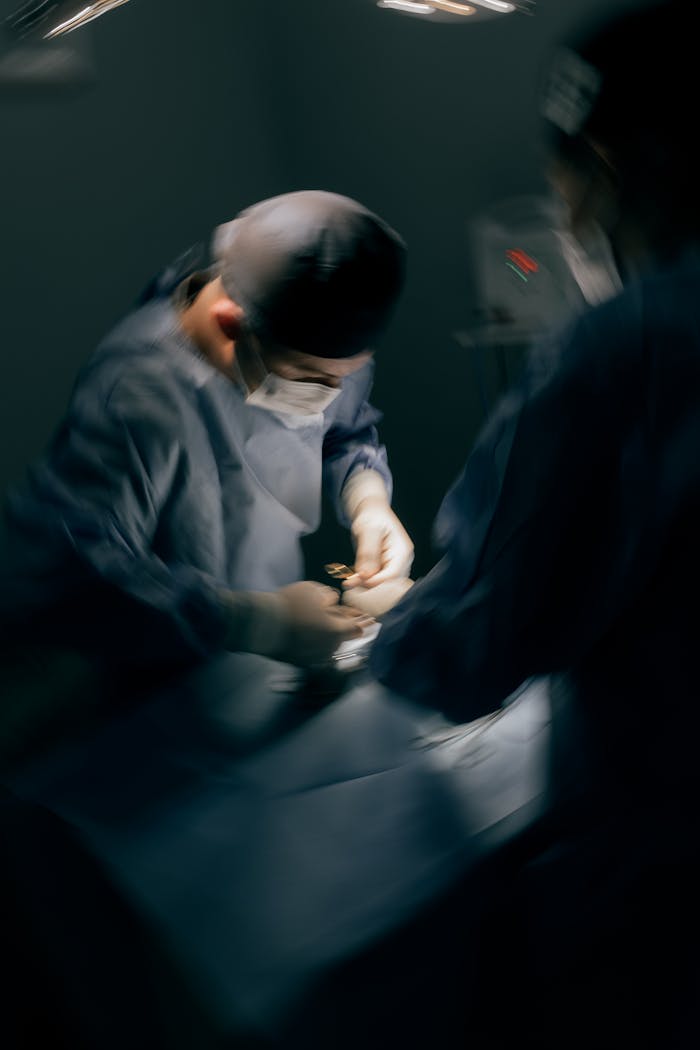 A team of surgeons focused on a critical surgery under operating room lights.